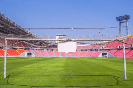 Soccer goal football on the green field inside the stadium with blue sky backgroundのeditorial素材