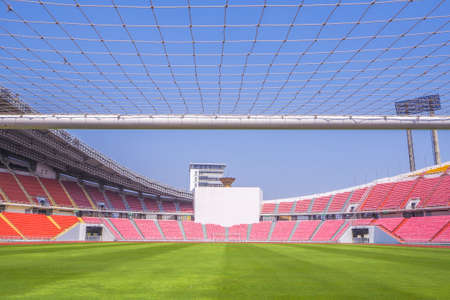 Soccer goal football on the green field inside the stadium with blue sky backgroundのeditorial素材