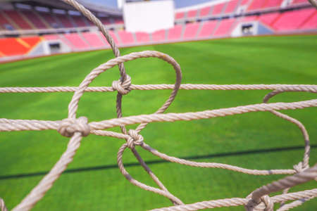 Football Net with green field inside the stadium backgroundの写真素材