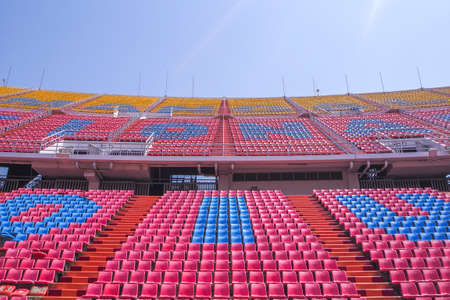 Rows of empty seat in football stadium with blue sky backgroundのeditorial素材