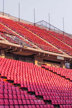 red Rows of empty seat in football stadium with white sky backgroundのeditorial素材