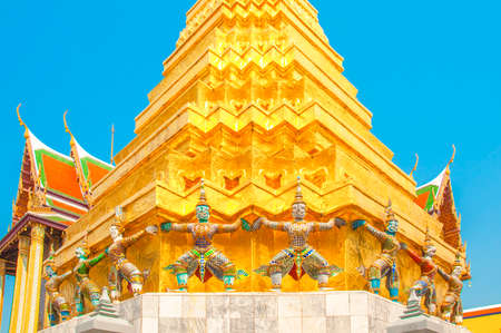 Giants under golden pagoda, Warrior statue with blue sky background at The Grand Palace and the temple Wat Phra Kaeo. Bangkok. Thailand, They are public domain or treasure of Buddhism.のeditorial素材