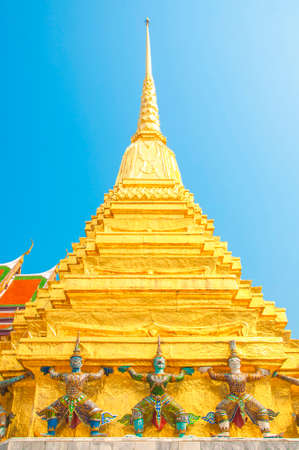 Giants under golden pagoda, Warrior statue with blue sky background at The Grand Palace and the temple Wat Phra Kaeo. Bangkok. Thailand, They are public domain or treasure of Buddhism.のeditorial素材