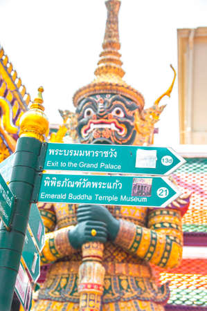 The Green Guide Post with Golden Temple and Giant Guardian Warrior Background at Wat Phra Kaew, Royal Grand Palace, Bangkok, Thailand.の写真素材