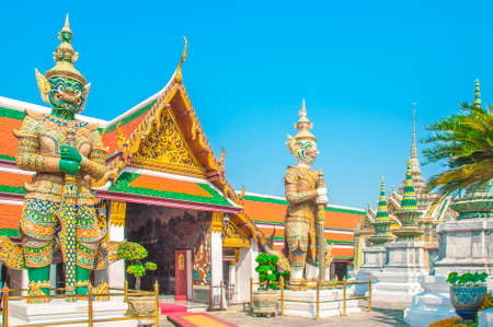 The Giant Demon Guardian with Temple and Blue Sky Background at Wat Phra Kaew, Grand Palace, Bangkok, Thailand.のeditorial素材