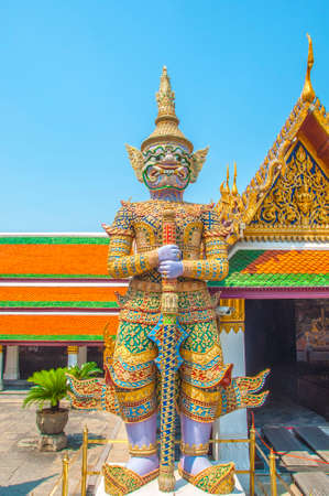 The Giant Demon Guardian with Temple and Blue Sky Background at Wat Phra Kaew, Grand Palace, Bangkok, Thailand.の写真素材