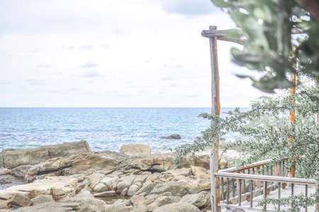 stone beach on sunny day with wooden walkway with blue sky background