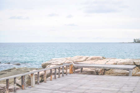 stone beach on sunny day with wooden walkway with blue sky backgroundの写真素材