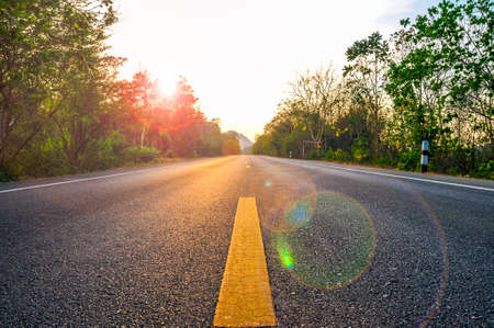 Close up road view of yellow center lines with white sky backgroundの写真素材