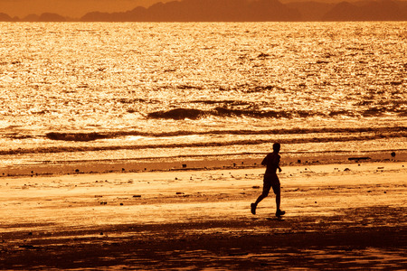 Running on the beach at sunsetの写真素材