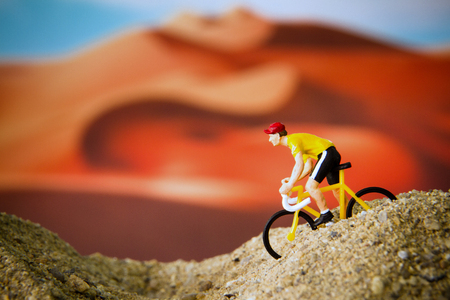 Miniature toy bicycle in desertの写真素材