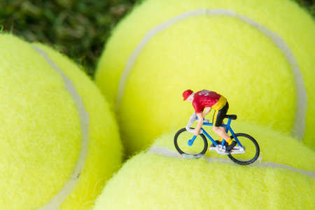Tiny toy bicycle on a tennis ball.の写真素材