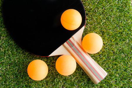 Table tennis racket and ball on grass.の写真素材