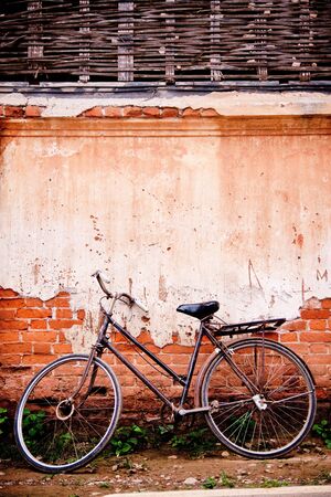Old bike parked beside the vintage old house.の写真素材