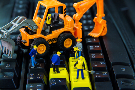 Tiny toys workers repair work on the computer keyboard.の写真素材