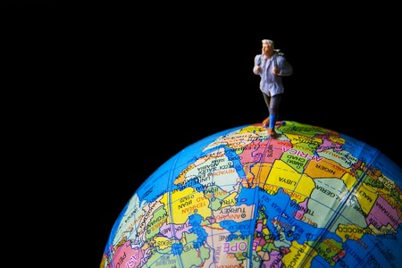 Tiny toy travel on the globe world.の写真素材