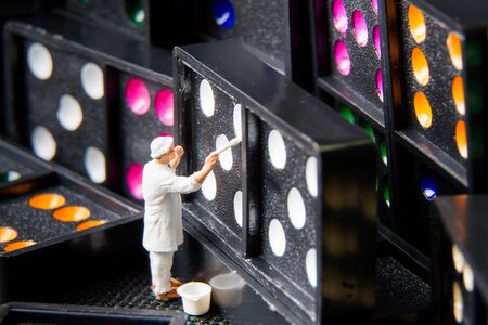 Tiny toy painter white on domino.の写真素材