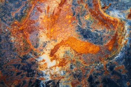 Rusty metal wall is a wall of an old oil tank.