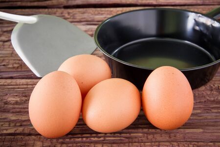 Brown chicken egg and iron pan on the tableの写真素材