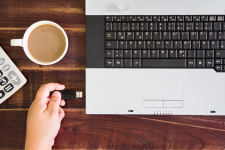 Laptop computer and hand with USB flash drive. selective focusの写真素材