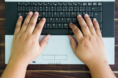 male hands on a notebook keyboard typingの写真素材