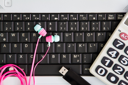 Notebook computer on the desk.Calculators,USB flash drive stick,Earphoneの写真素材