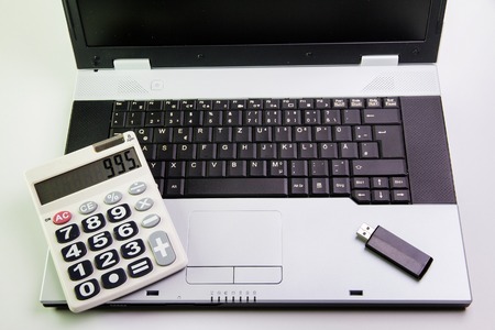 Notebook computer on the desk.Calculators,USB flash drive stickの写真素材