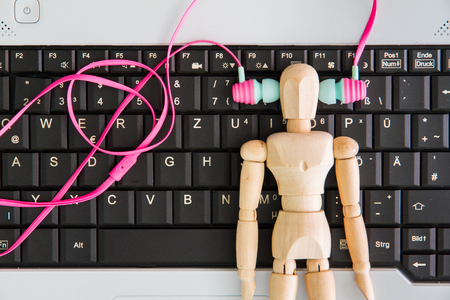 Notebook computer on the desk,Earphone,wooden manの写真素材