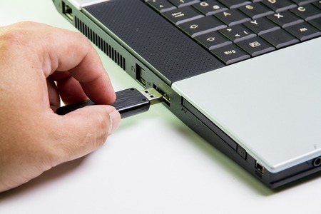 Laptop computer and hand with USB flash drive. selective focusの写真素材