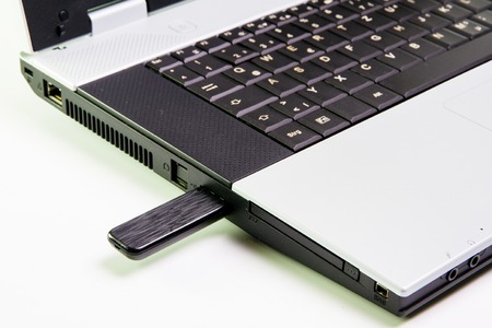 Notebook computer on the desk.USB flash drive stickの写真素材