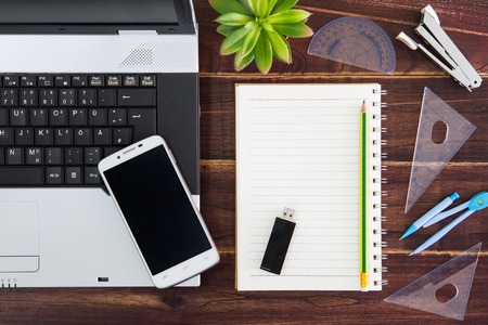 Notebook computer on the desk.USB flash drive stick,paper,smartphoneの写真素材