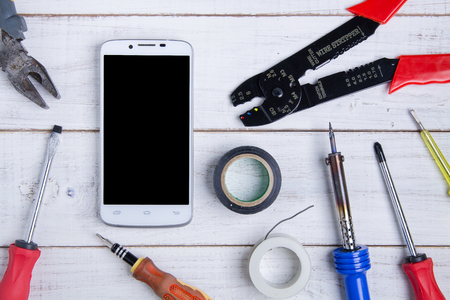 smartphone and equipment repair on the white wooden background.の写真素材
