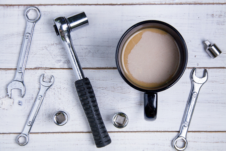 Coffee cup and equipment repair on the white wooden background.の写真素材