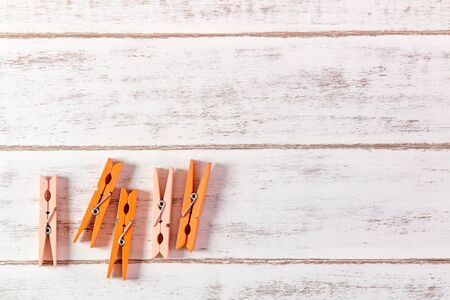 Orange clothes peg on wooden table.の写真素材