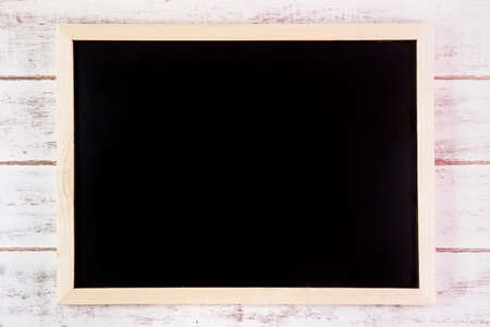 Blank blackboard on wooden table.Template mock up for adding your design and leave space beside frame for adding more textの写真素材
