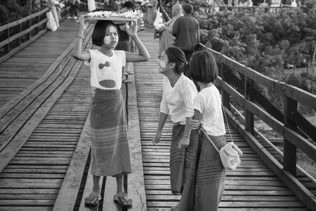 Sagklaburi, Kanchanaburi, Thailand - May, 01, 2015 : Unidentified name florist child sell flowers for Buddha on the wood bridge in the moring at Sagklaburi, Kanchanaburi, Thailand.Black and white pictureのeditorial素材