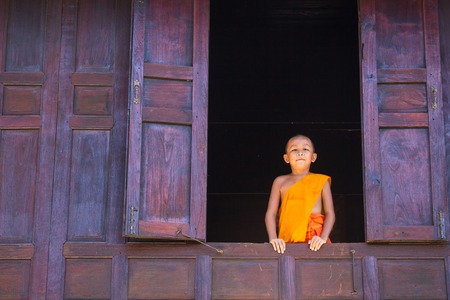 Angtong,Thailand, - May, 17, 2015 : Unidentified name novice monks in old wooden window at Wat Muang Angtong,Thailandのeditorial素材