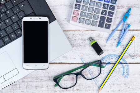 Top view of laptop, calculator, glasses, pencil, ruler, smartphone and USB flash drive on the accountant white table.Business concept.の写真素材