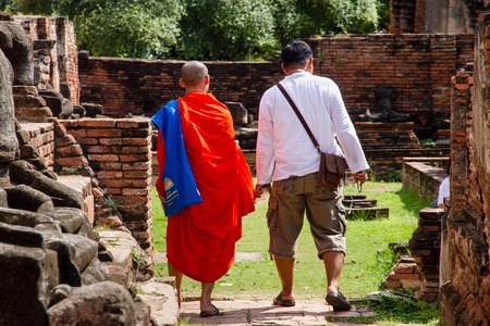 Ayutthaya, Thailand - October, 21, 2016 : Unidentified name buddhist monk walks tourist to visit at Wat Mahathat, Ayutthaya, Thailandのeditorial素材