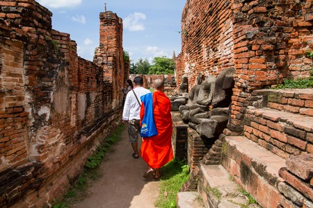 Ayutthaya, Thailand - October, 21, 2016 : Unidentified name buddhist monk walks tourist to visit at Wat Mahathat, Ayutthaya, Thailandのeditorial素材