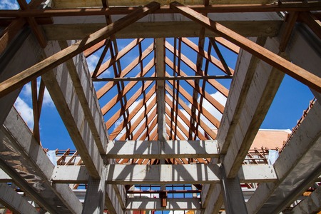 Low angle view of roof trusses and framing wooden of new house construction.の写真素材