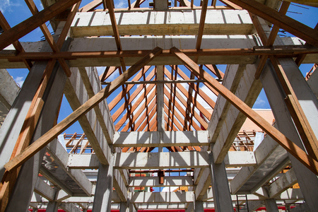 Low angle view of roof trusses and framing wooden of new house construction.の写真素材