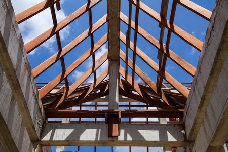 Low angle view of roof trusses and framing wooden of new house construction.の写真素材