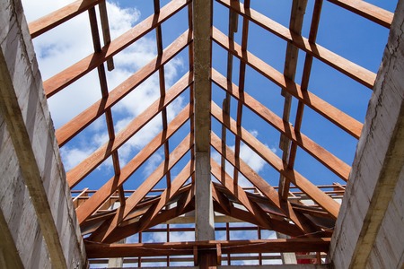 Low angle view of roof trusses and framing wooden of new house construction.の写真素材