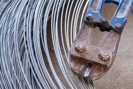 Pliers cutting rebar and thick galvanised aluminium iron metal wire.の写真素材