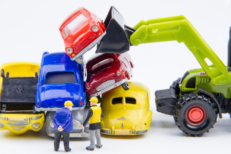 Miniature tiny toys doing business about cemetery car was damaged by a car accident and old cars.Detail of industrial crane claw grabbing old car for recycling in car scrap yard. Car industry backgroundの写真素材