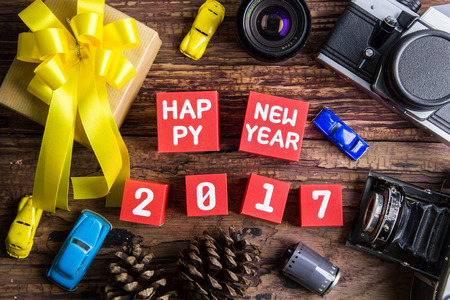 Present gift box design wrapped in color paper with bows, vintage old camera and Happy new year 2017 number on red paper box cubes on a wooden background.Christmas and New Year background,の写真素材