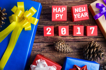 Present gift box design wrapped in color paper with bows and Happy new year 2017 number on red paper...