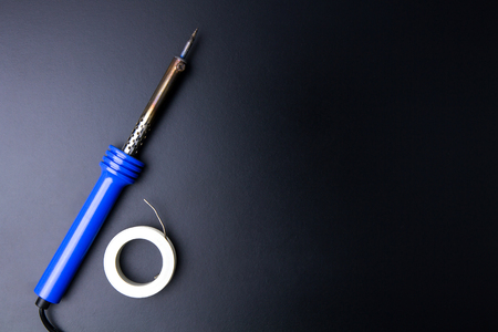 Soldering iron construction tools on a black background with light copy space.maintenance concept.の写真素材