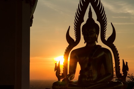 Silhouette of Buddha in a temple at evening sunset background.Thailand.の写真素材